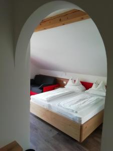 um quarto com uma cama grande e um arco em Pension Runer em Terlano