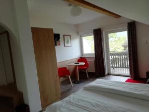 Schlafzimmer mit einem Bett, einem Fenster und einem Tisch in der Unterkunft Pension Runer in Terlan