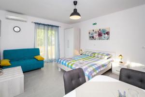 a bedroom with a bed and a blue couch at Apartments Balach in Poreč