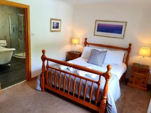 a bedroom with a bed and a bath tub at Tower Ridge House in Fort William