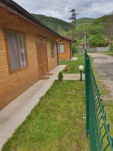 a fence in front of a house with a porch at ЕКО БУНГАЛА in Trŭn