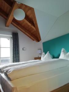 ein Schlafzimmer mit einem großen weißen Bett und einem Fenster in der Unterkunft Pension Runer in Terlan