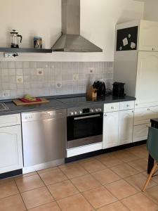 a kitchen with white cabinets and a stove top oven at Fewo Moselblick in Traben-Trarbach