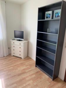 a room with a book shelf and a tv and a dresser at Fewo Moselblick in Traben-Trarbach