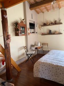 La Casa di Biba في Massa Lombarda: غرفة نوم بسرير وطاولة وكراسي