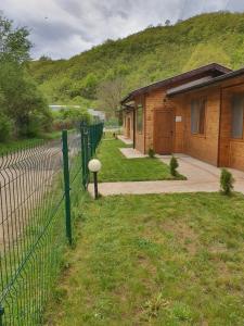 a fence in front of a house next to a building at ЕКО БУНГАЛА in Trŭn