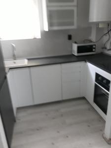 希歐福克的住宿－Kinga，厨房配有白色橱柜和微波炉
