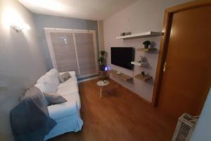 een woonkamer met een witte bank en een televisie bij Apartamento moderno Timanfaya in Santa Cruz de Tenerife