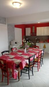 ein Esszimmer mit einem Tisch mit rotem Tischtuch in der Unterkunft maison en pierre de pays in Ségrie