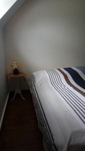 ein Schlafzimmer mit einem Bett und einem Tisch mit einer Lampe in der Unterkunft maison en pierre de pays in Ségrie