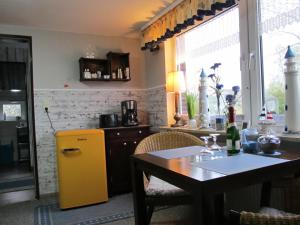 Il comprend une cuisine équipée d'un réfrigérateur jaune et d'une table. dans l'établissement Landhaus beim See, à Großheide