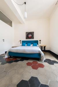 a bedroom with a large bed with blue pillows at Via Garibaldi 31 Suites in Turin
