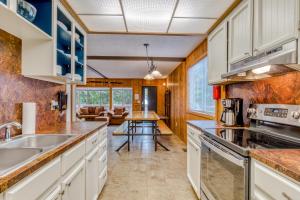 a kitchen with white cabinets and a living room at Mt Hood Chalet Vacation Rental in Government Camp