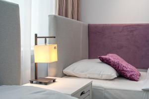 sypialnia z łóżkiem z lampką i poduszką w obiekcie Nasze Kamienice Studio 3 5 7 w mieście Rzeszów