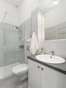 biała łazienka z umywalką i toaletą w obiekcie Nasze Kamienice Studio 3 5 7 w mieście Rzeszów