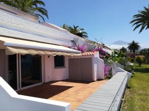 ein weißes Haus mit einer Veranda und einem Zaun in der Unterkunft Sunset La Palmita in La Victoria de Acentejo