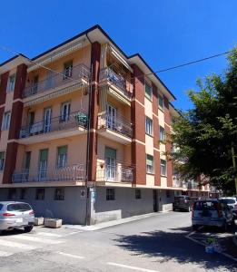 un edificio de apartamentos con coches estacionados frente a él en LE PALME Loft Apartment en Fossano
