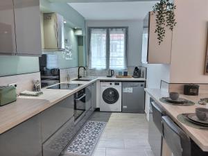 a kitchen with a washer and dryer in it at La villageoise in Dammartin-en-Goële