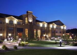 - un grand bâtiment la nuit avec des lumières dans l'établissement ClubHouse Hotel & Suites Fargo, à Fargo