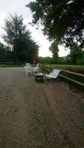 zwei Bänke und ein Picknicktisch neben einem Zaun in der Unterkunft maison en pierre de pays in Ségrie