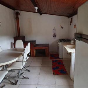 uma cozinha com uma mesa, cadeiras e um fogão em CASA ACALANTA-Trilha das Flores-SERRA DA CANASTRA em São José do Barreiro