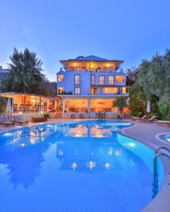 a large swimming pool in front of a building at Olea Nova Hotel in Kaş