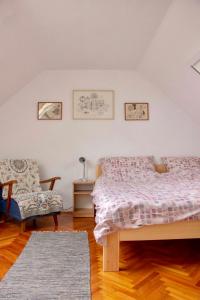 a bedroom with a bed and a chair at Hajdu Lovasudvar Hortobágy in Hortobágy