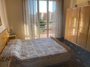 a bedroom with a bed and a large window at Apartment via Antica Romana in Sestri Levante