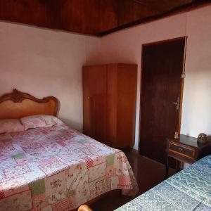 um quarto com duas camas e uma porta para um armário em CASA ACALANTA-Trilha das Flores-SERRA DA CANASTRA em São José do Barreiro