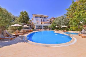 a large swimming pool with chairs and a house at Olea Nova Hotel in Kas