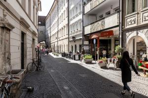 a woman walking down a street in a city at Stay COOPER l Tivoli in Bolzano