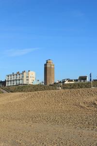 a view of a sandy beach with buildings in the background at Hotel Arosa in Zandvoort