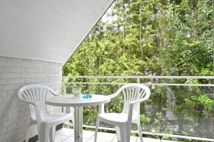 una mesa blanca y 2 sillas en un balcón con ventana en Studio, Nähe Dieksee en Malente
