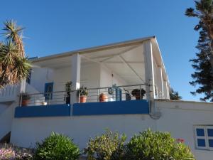 a house with a balcony with potted plants on it at Villa Giorgos in Kefalos