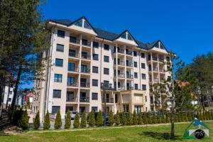 a large white building with trees in front of it at Lux Apartman Lea - Vila Esla 1 in Zlatibor