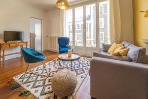 una sala de estar con un sofá y una mesa en Tours Hyper Centre - Balcon - Arrivée autonome, en Tours