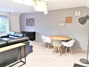 uma sala de estar com uma mesa e um sofá em Greyhound - Grand Appartement centre-ville em Soissons