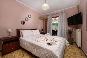 Seaview Cottage - Calmare في Petrití: غرفة نوم عليها سرير وورد