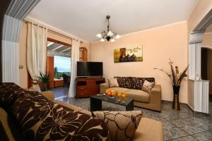 uma sala de estar com um sofá e uma televisão em Seaview Cottage - Calmare em Petrití