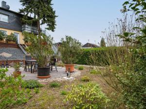 einen Garten mit Topfpflanzen und ein Haus in der Unterkunft Restful Apartment in Neumagen near River Moselle in Neumagen