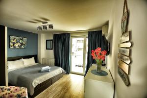a bedroom with a bed and a vase with red flowers at Mario Apartamente - Romantic Mamaia in Mamaia