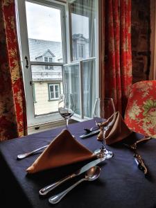 una mesa con copas de vino y servilletas en una mesa con ventana en Le Clos Saint-Louis en Quebec