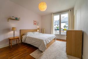 Un dormitorio con una cama y una ventana grande. en Tours Hyper Centre - Balcon - Arrivée autonome, en Tours