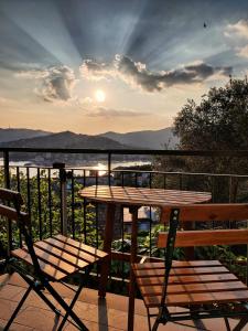 una mesa y sillas en un balcón con vistas a la puesta de sol en Tra Sole & Mare, en Zoagli