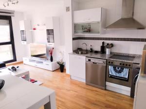 Una cocina con gabinetes blancos y una estufa. en APARTAMENTO KENITRA, en Avilés