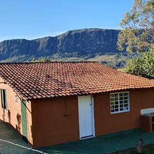 una casa con techo con una montaña en el fondo en CASA ACALANTA-Trilha das Flores-SERRA DA CANASTRA en São José do Barreiro