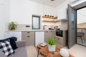 a kitchen with a table and a living room at MATALA * LUX CAVE in Matala