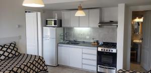 a kitchen with a refrigerator and a stove top oven at Bariloche Modern Apartment in San Carlos de Bariloche