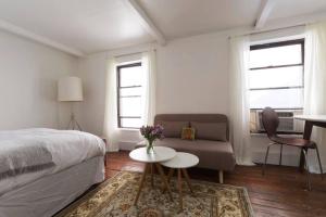 紐約的住宿－Cozy bright studio - Soho/Greenwich Village - 30+Days Only，一间卧室配有一张床、一张桌子和一张沙发