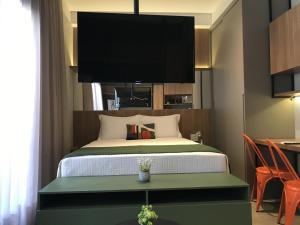 een slaapkamer met een bed en een flatscreen-tv erboven bij 360 VN Capote Valente by Housi in Sao Paulo